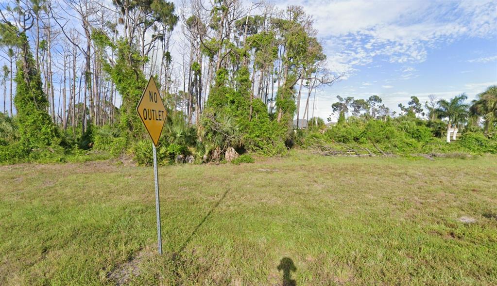 A yellow no outlet sign stands in a grassy, undeveloped lot with surrounding trees — 285 ROTONDA BOULEVARD S, ROTONDA WEST, FL