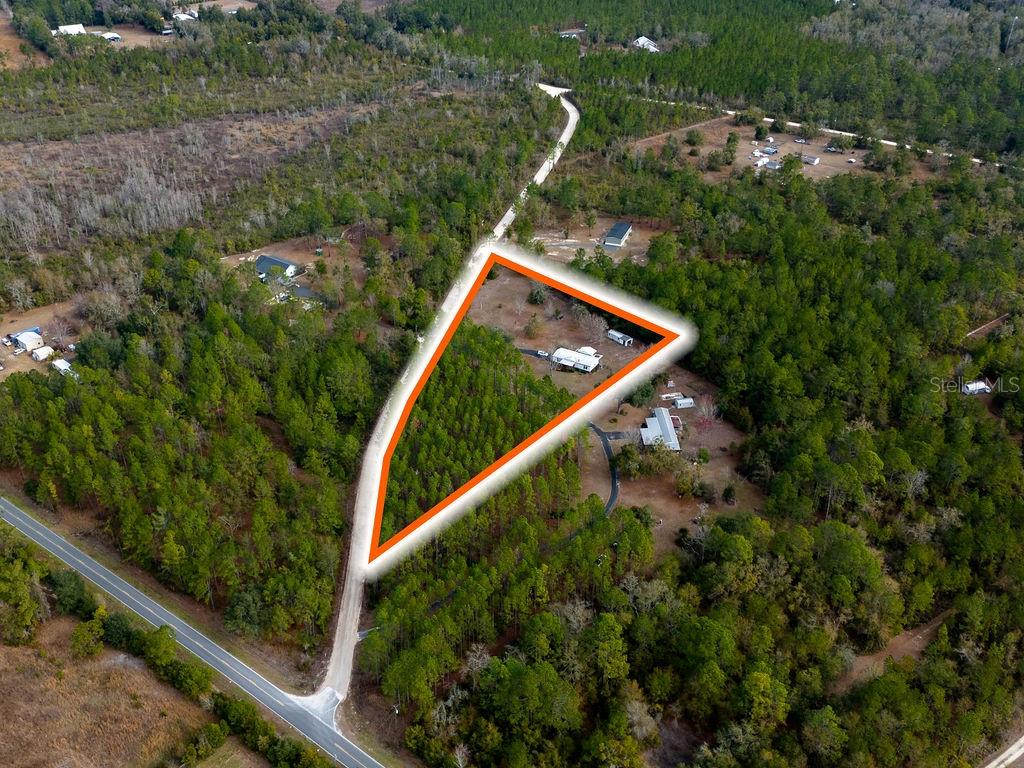 An aerial view shows a triangular-shaped residential lot with a house and driveway — 2774 140TH TERRACE, LAKE CITY, FL