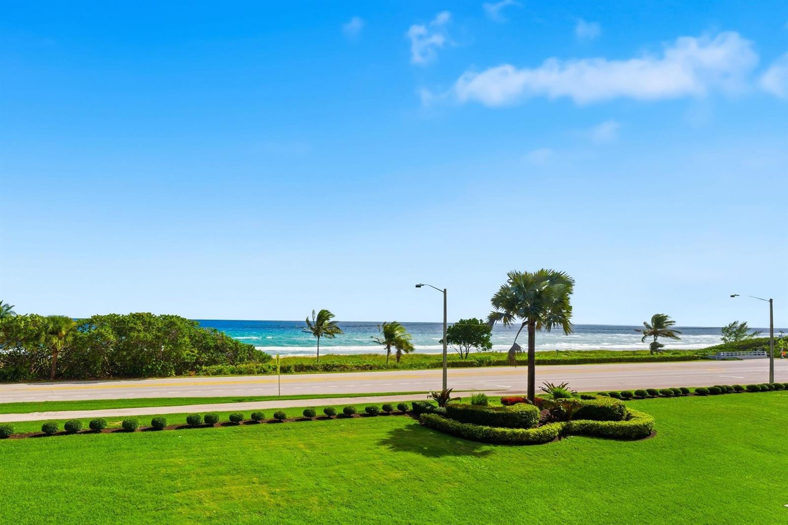 A view of a grassy lawn, a road, and the ocean under a blue sky — 2727 N Ocean Boulevard Unit 301, Boca Raton FL 33431, BOCA RATON, FL