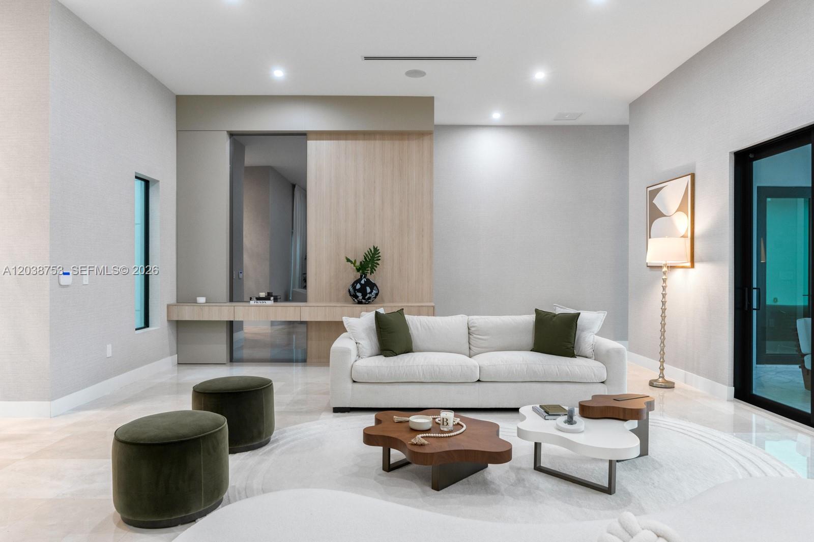 A modern living room features a white sofa, olive green ottomans, and wood-paneled accent wall — 80 NW 129th Ave, Miami FL 33182, MIAMI, FL