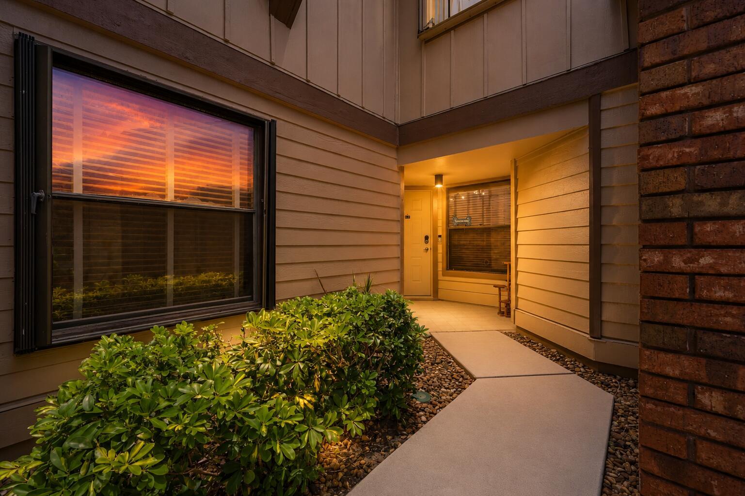 A concrete walkway leads to the front entrance of a house with tan siding — 600 Crosswinds # E1, FL 33413, FL