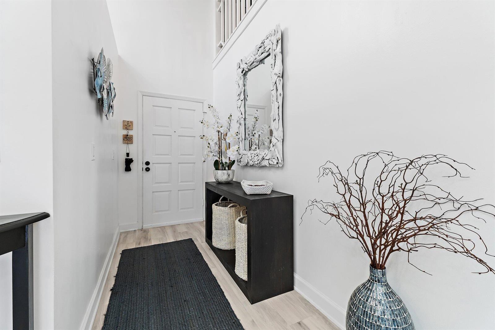 A bright entryway features a dark console table, a mirror, and a black runner rug — 4161 S Us Highway 1 # E3, Jupiter FL 33477, JUPITER, FL