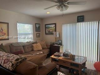 A living room features a beige sofa, a wooden coffee table, and vertical window blinds — MARGATE, FL