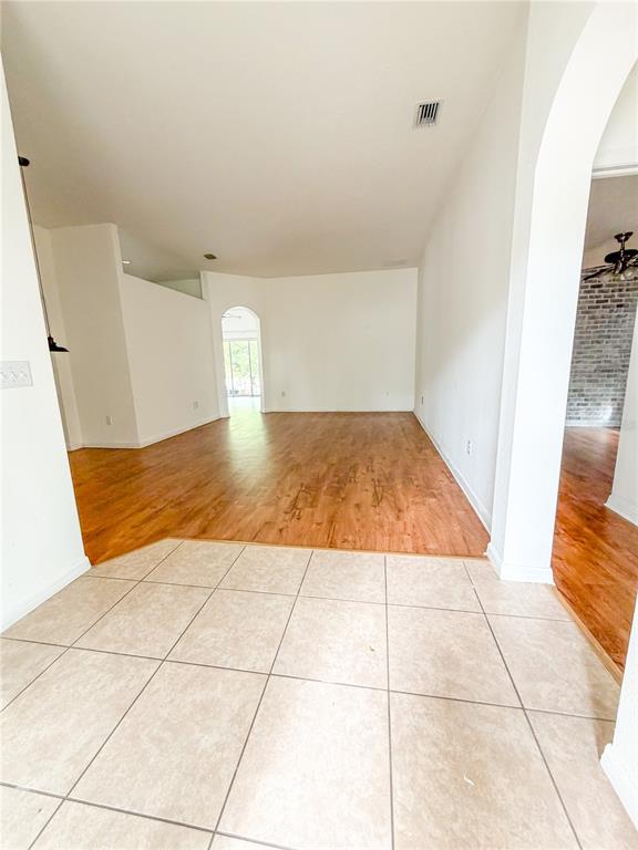 A tiled entryway leads to a large living area with wood-look flooring and arched doorways — 3229 DUNSTABLE DRIVE, LAND O LAKES, FL