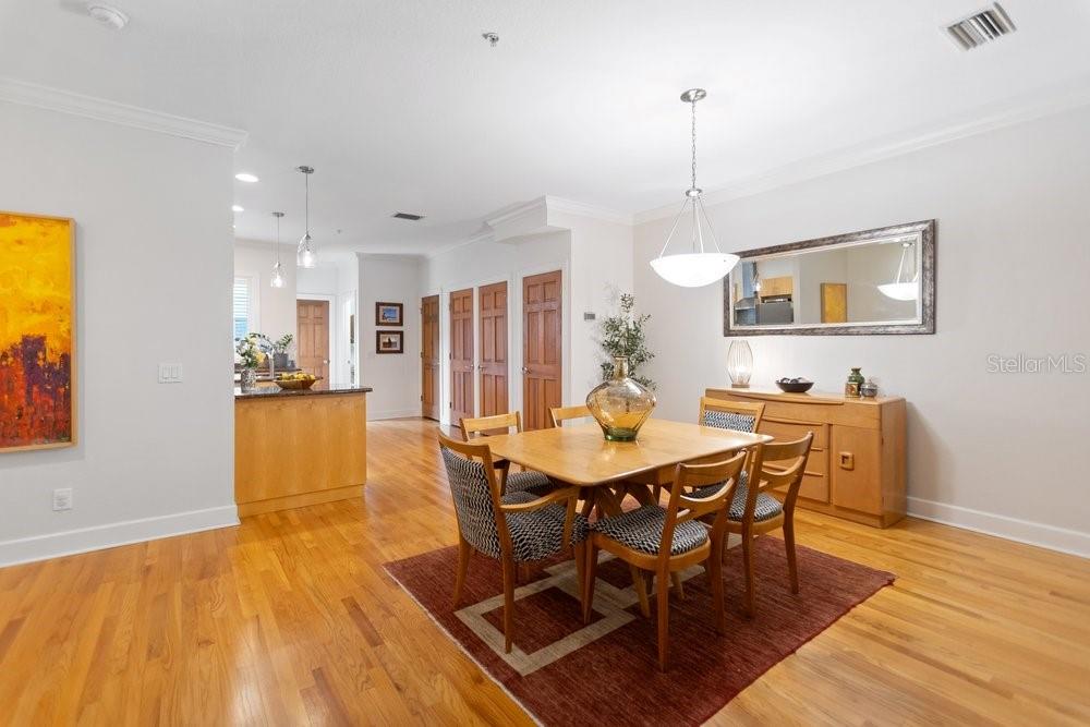 A dining room with hardwood floors, a wooden table, four chairs, and a sideboard — 514 S GLEN AVENUE, TAMPA, FL