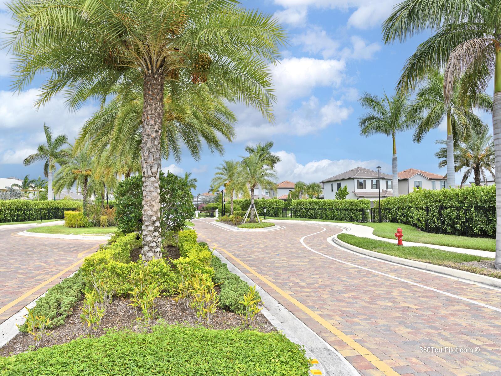 A paved road winds through a residential neighborhood lined with palm trees and manicured hedges — 4814 Chantilly Road, Lake Worth FL 33467, LAKE WORTH, FL