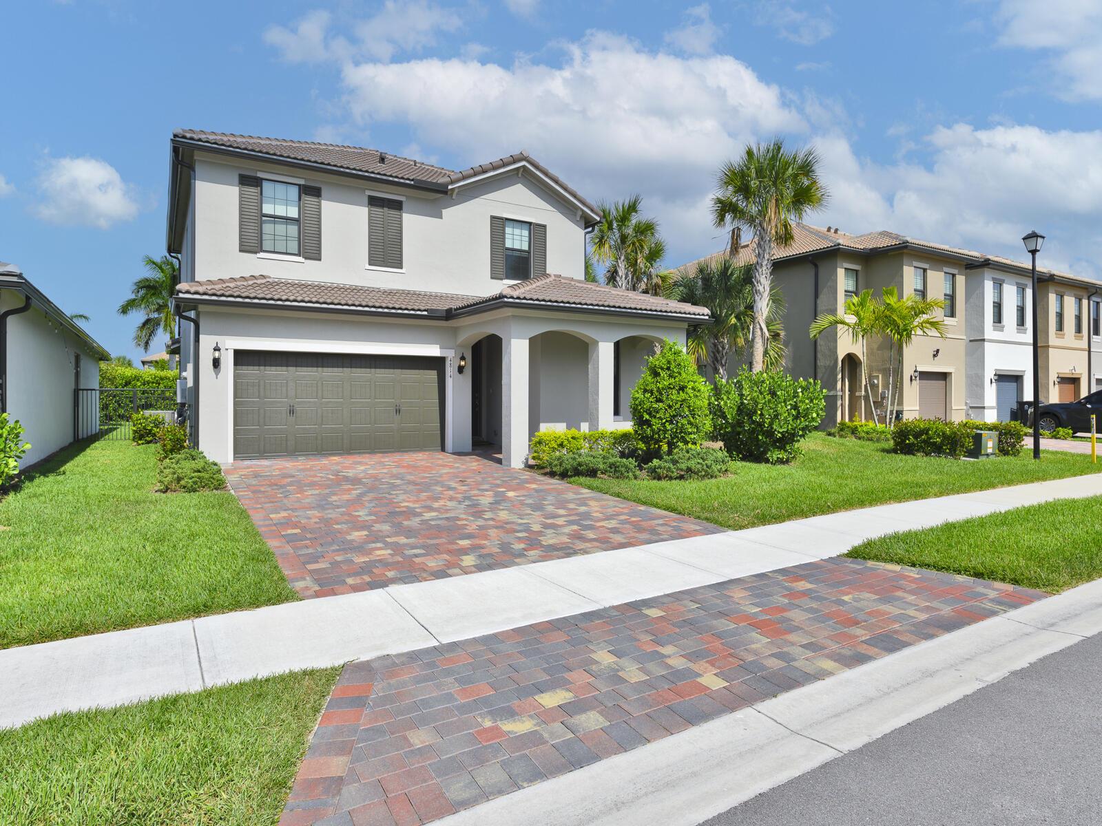 A two-story suburban house with a multi-colored paver driveway and a two-car garage — 4814 Chantilly Road, Lake Worth FL 33467, LAKE WORTH, FL