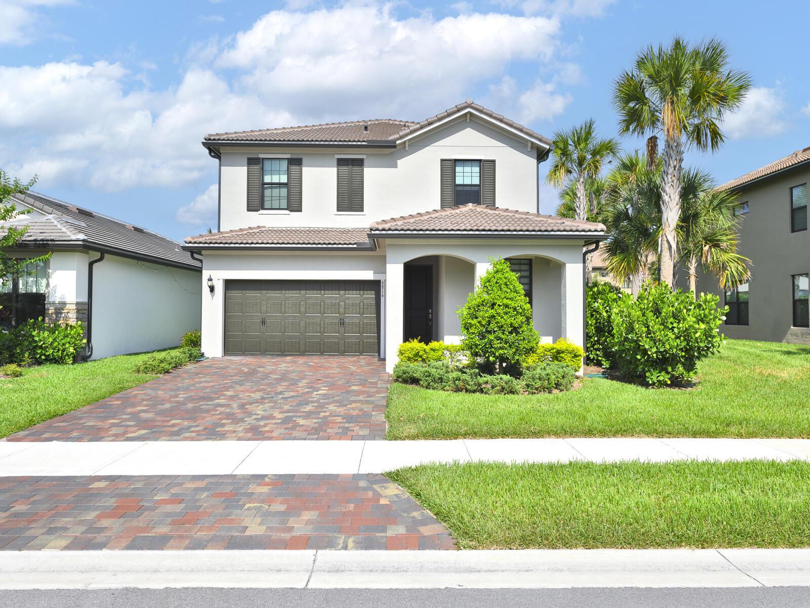 A two-story house with a brick paver driveway, a two-car garage, and palm trees — 4814 Chantilly Road, Lake Worth FL 33467, LAKE WORTH, FL