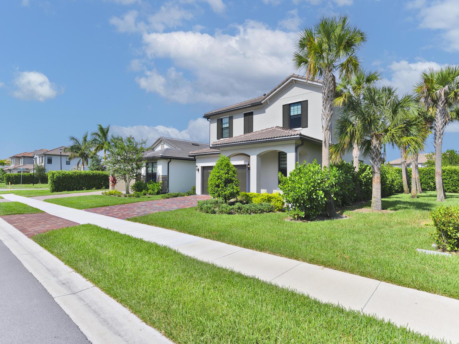 A two-story suburban house with a paved driveway, palm trees, and a manicured lawn — 4814 Chantilly Road, Lake Worth FL 33467, LAKE WORTH, FL