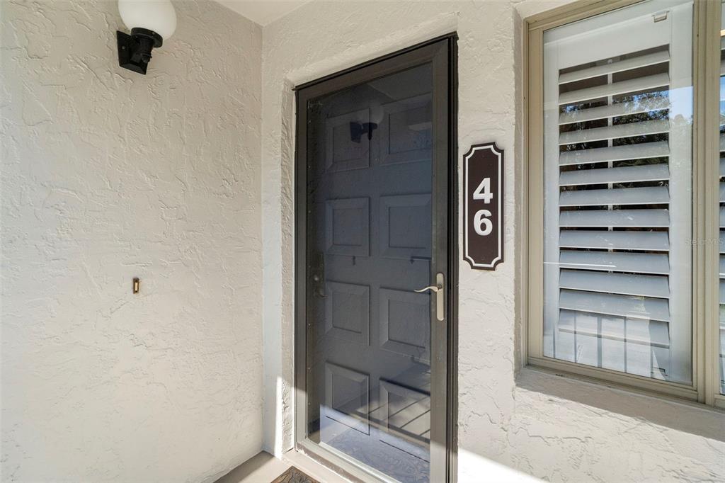 A front entrance features a dark storm door, a house number plaque, and a window — 5 ESCONDIDO CIRCLE UNIT 46, ALTAMONTE SPRINGS, FL