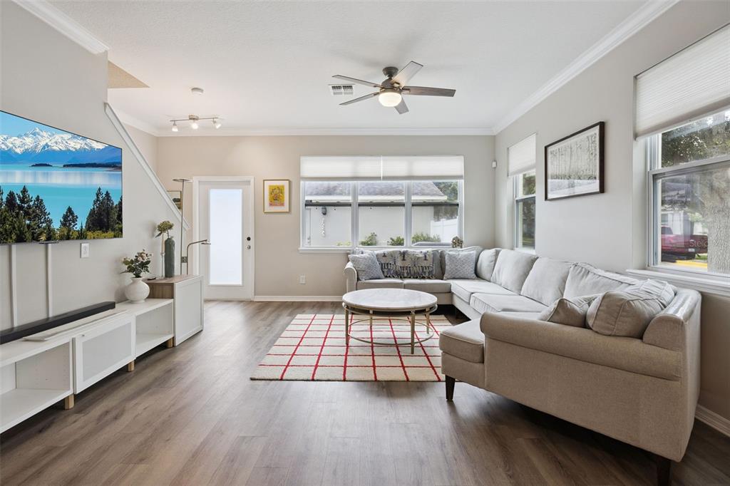 A living room features a sectional sofa, a round coffee table, and a wall-mounted television — 12303 LANGSTAFF DRIVE, WINDERMERE, FL