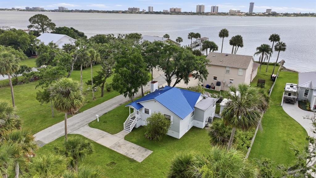An aerial view shows a house with a blue metal roof near a large body — 105 MCDONALD STREET, SOUTH DAYTONA, FL