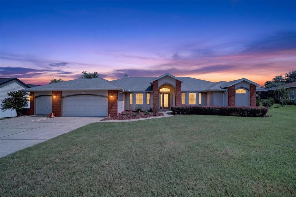 A single-story house with a brick facade, three-car garage, and a large front lawn — 2319 SE 30TH STREET, OCALA, FL