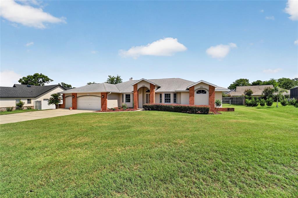 A single-story house with a brick and stucco exterior, a multi-car garage, and a lawn — 2319 SE 30TH STREET, OCALA, FL