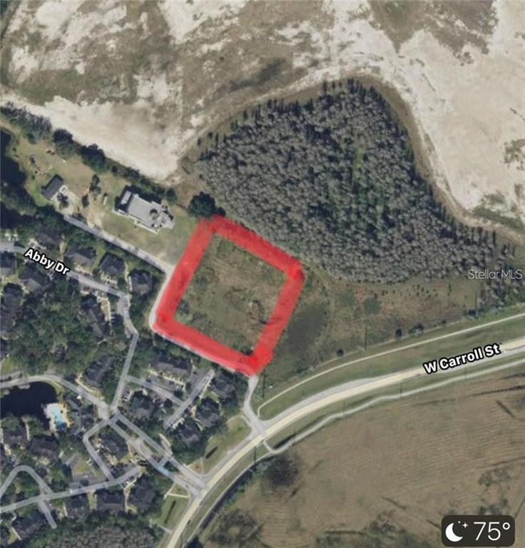 An aerial map view shows a rectangular plot of land outlined in red near roads — NANAKSAR LANE, KISSIMMEE, FL