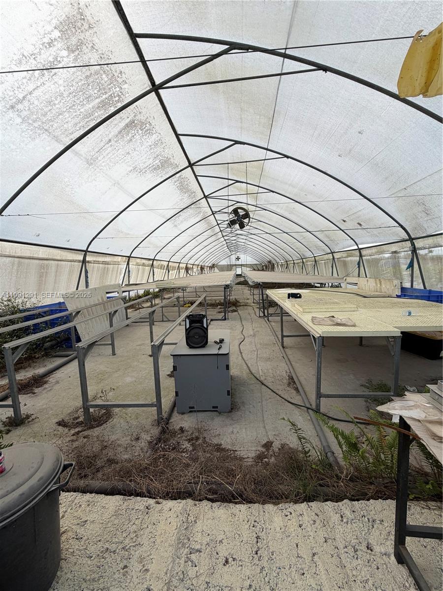 An interior view of a greenhouse featuring metal tables and a concrete floor — SW 169 Ave, Miami FL 33187, MIAMI, FL