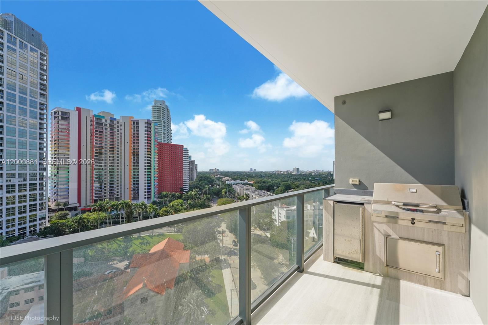 A high-rise balcony features a built-in outdoor kitchen with a grill and city views — 1451 Brickell Ave # 1203, Miami FL 33131, MIAMI, FL
