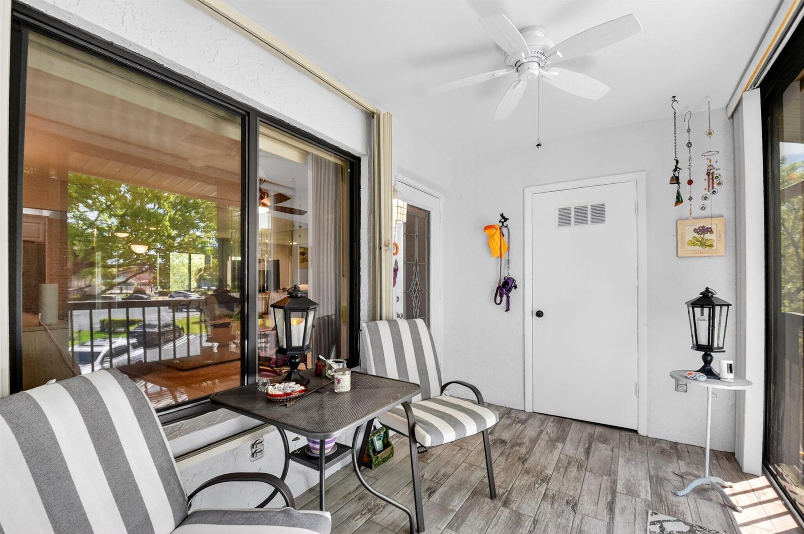 A covered patio features striped chairs, a small table, a ceiling fan, and tiled flooring — 207 Pine Hov Circle # D2, FL 33463, FL