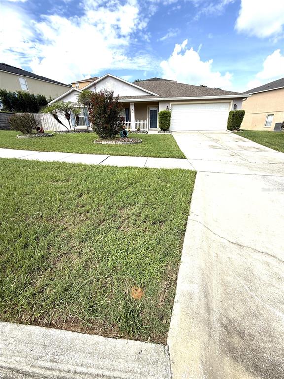A single-story house with a white garage door, a front lawn, and a concrete driveway — 344 SKY VALLEY STREET, CLERMONT, FL