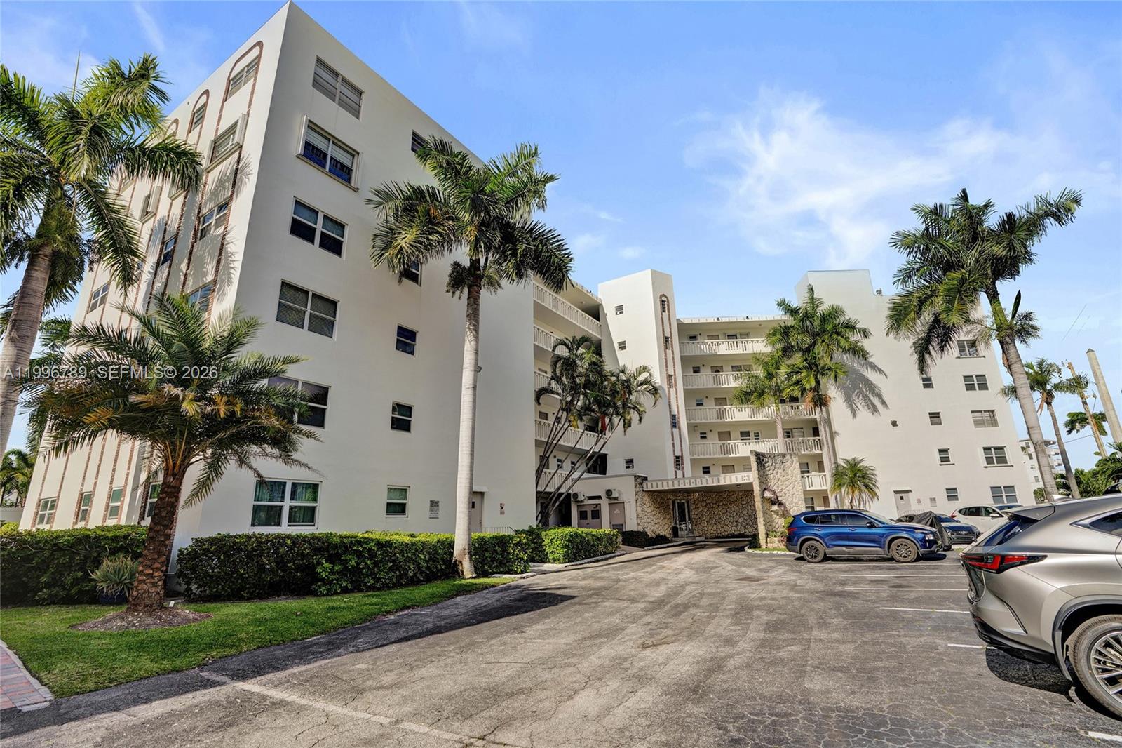 A multi-story white apartment building with palm trees and a parking lot in front — 3181 S Ocean Dr, Hallandale Beach FL 33009, HALLANDALE BEACH, FL