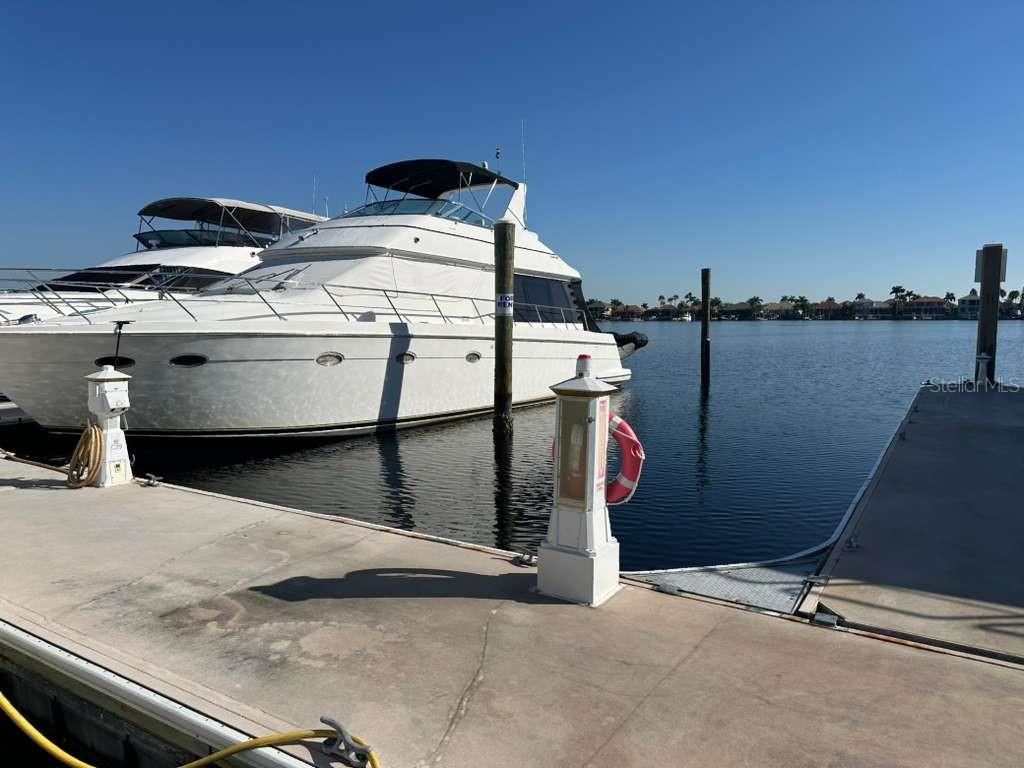 A large white motor yacht is docked at a concrete pier on a sunny day — 102 RIVIERA DUNES WAY UNIT C29, PALMETTO, FL