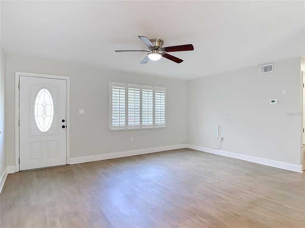 An aerial view shows a single-story house with a garage, driveway, and fenced backyard — 108 ORANGE AVENUE, EDGEWATER, FL