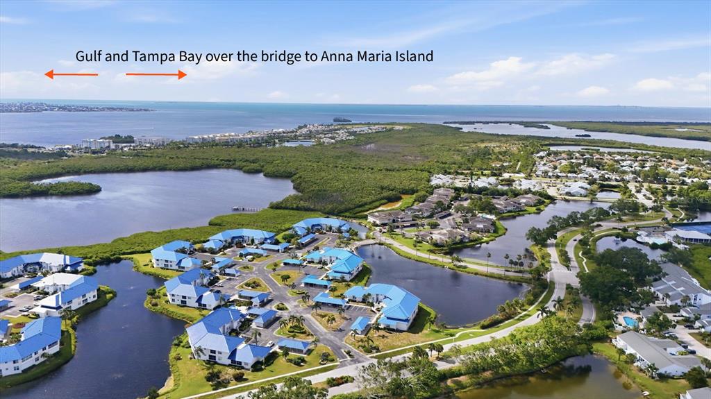 An aerial view shows a swimming pool and hot tub surrounded by residential buildings — 879 AUDUBON DRIVE UNIT 879, BRADENTON, FL