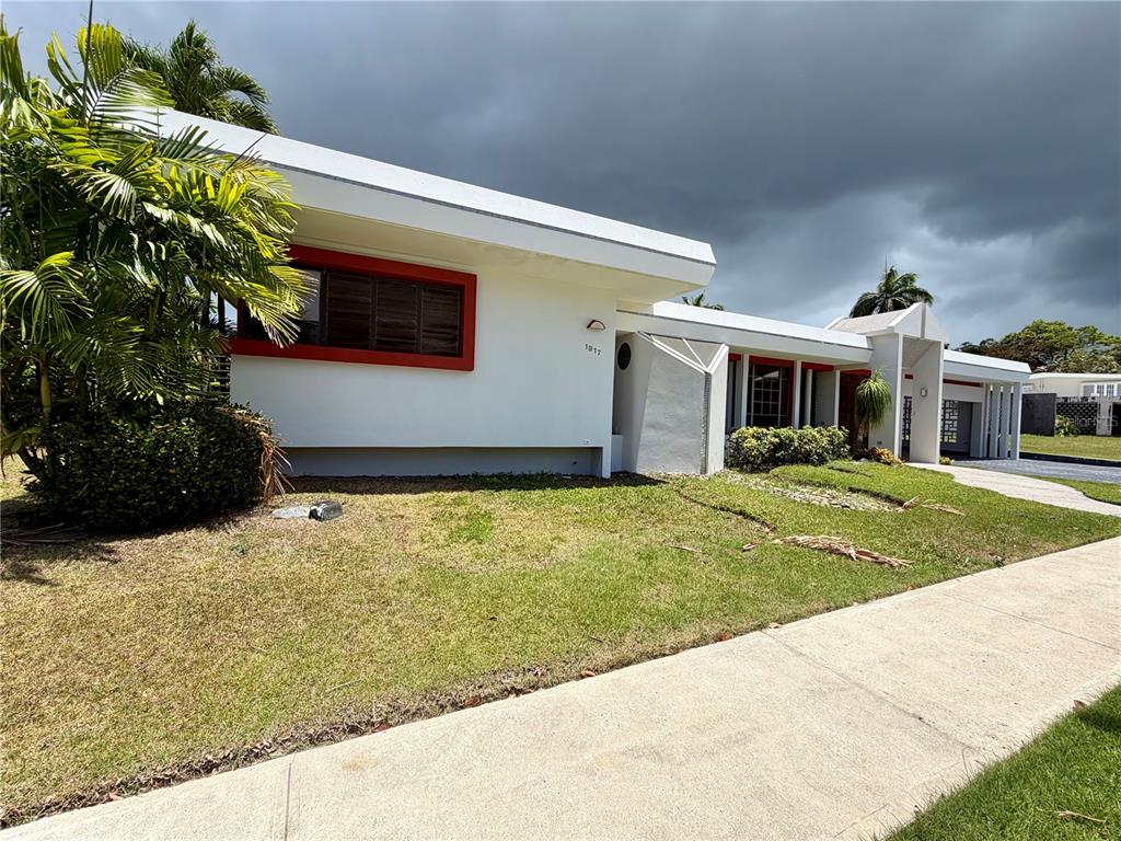 A white mid-century modern house features red window trim and a flat roof — 1917 ORQUIDEA, SAN JUAN, PR