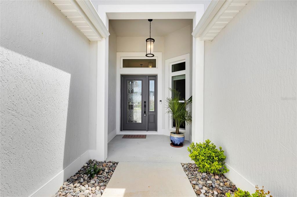An aerial view shows suburban houses with fenced backyards, swimming pools, and a putting green — 5495 HAWKINS DRIVE, THE VILLAGES, FL