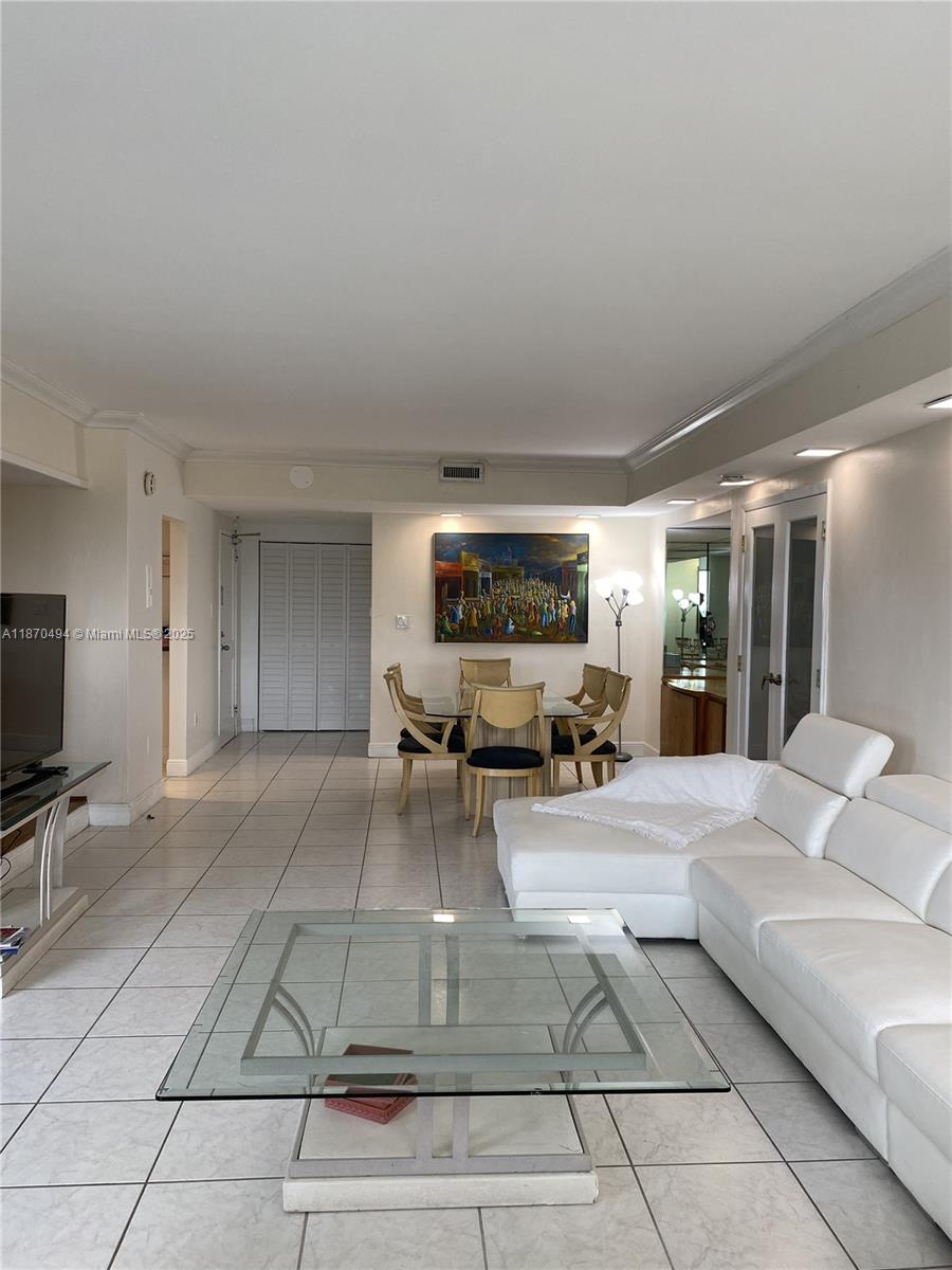 A living and dining area features white tile floors, a white sectional sofa, and glass furniture — 10185 Collins Ave # 319, Bal Harbour FL 33154, BAL HARBOUR, FL