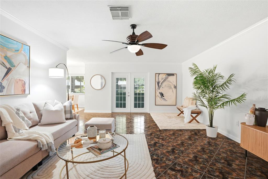 A living room features dark tiled floors, a ceiling fan, and a light-colored sofa — 1208 14TH CIRCLE SE, LARGO, FL