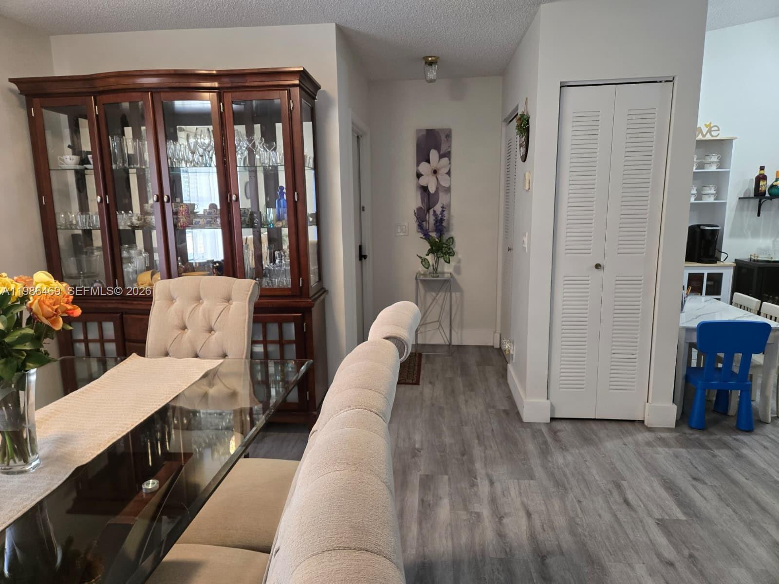 A dining area features a glass table, a wooden hutch, and light wood-look flooring — 3815 Coco Loba Ln, Boynton Beach FL 33436, BOYNTON BEACH, FL