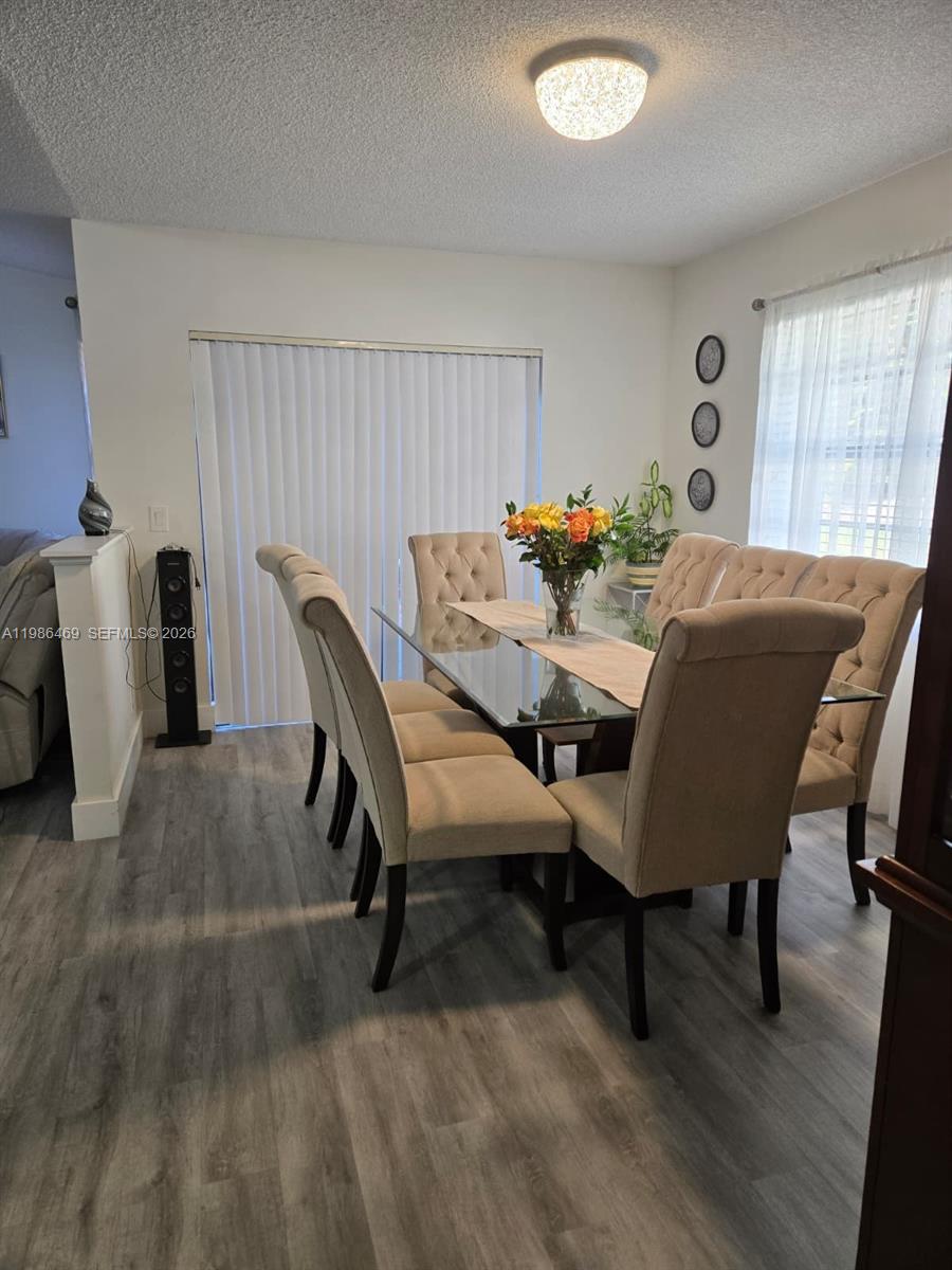A dining room features a glass-topped table, tufted chairs, and gray wood-look flooring — 3815 Coco Loba Ln, Boynton Beach FL 33436, BOYNTON BEACH, FL