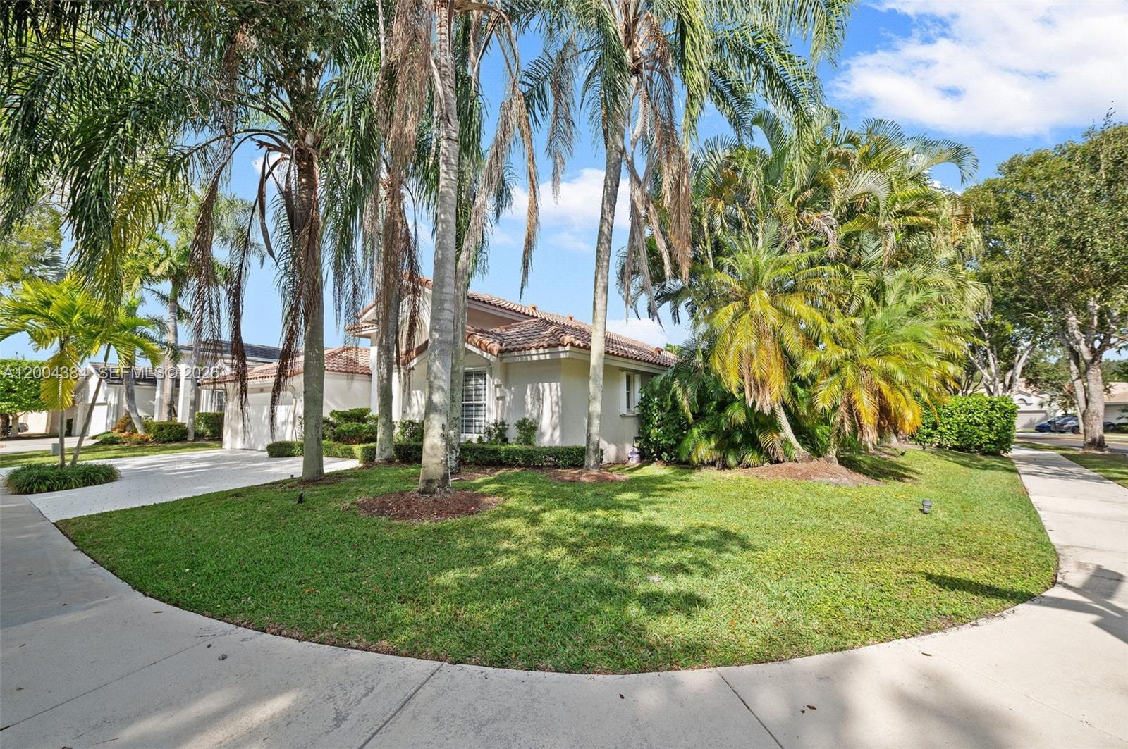 A single-story house with a tile roof, palm trees, and a paved driveway — 765 Bayside Ln, Weston FL 33326, WESTON, FL