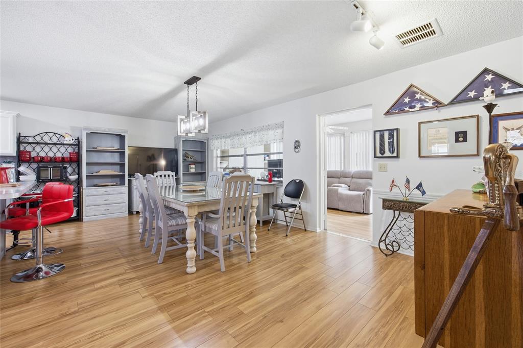 A yellow single-story house with a front porch sits on a grassy lot with trees — 9335 SW 85TH TERRACE UNIT E, OCALA, FL