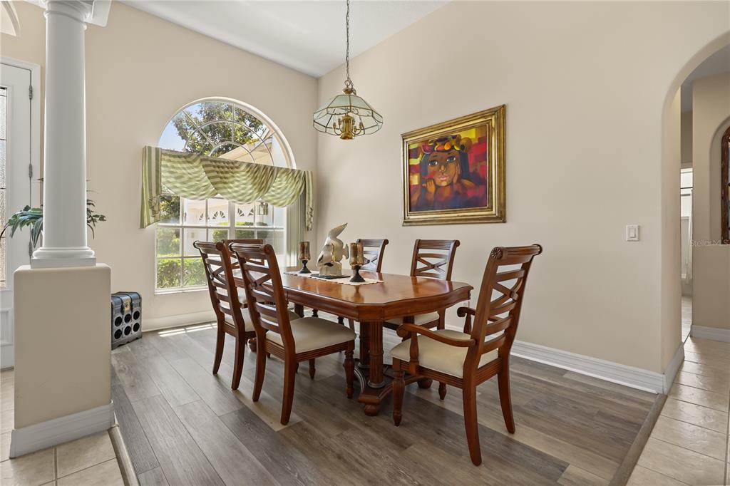 A dining room features a wooden table, six chairs, a chandelier, and an arched window — 4332 FAWN MEADOWS CIRCLE, CLERMONT, FL