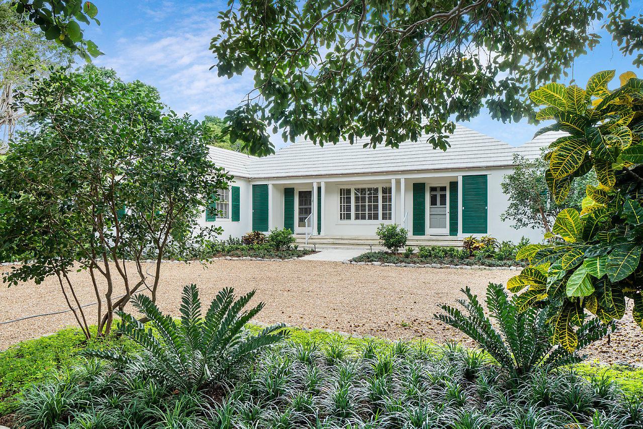 A white single-story house with green shutters sits behind a gravel driveway and landscaping — 1008 N Ocean Boulevard, Gulf Stream FL 33483, GULF STREAM, FL