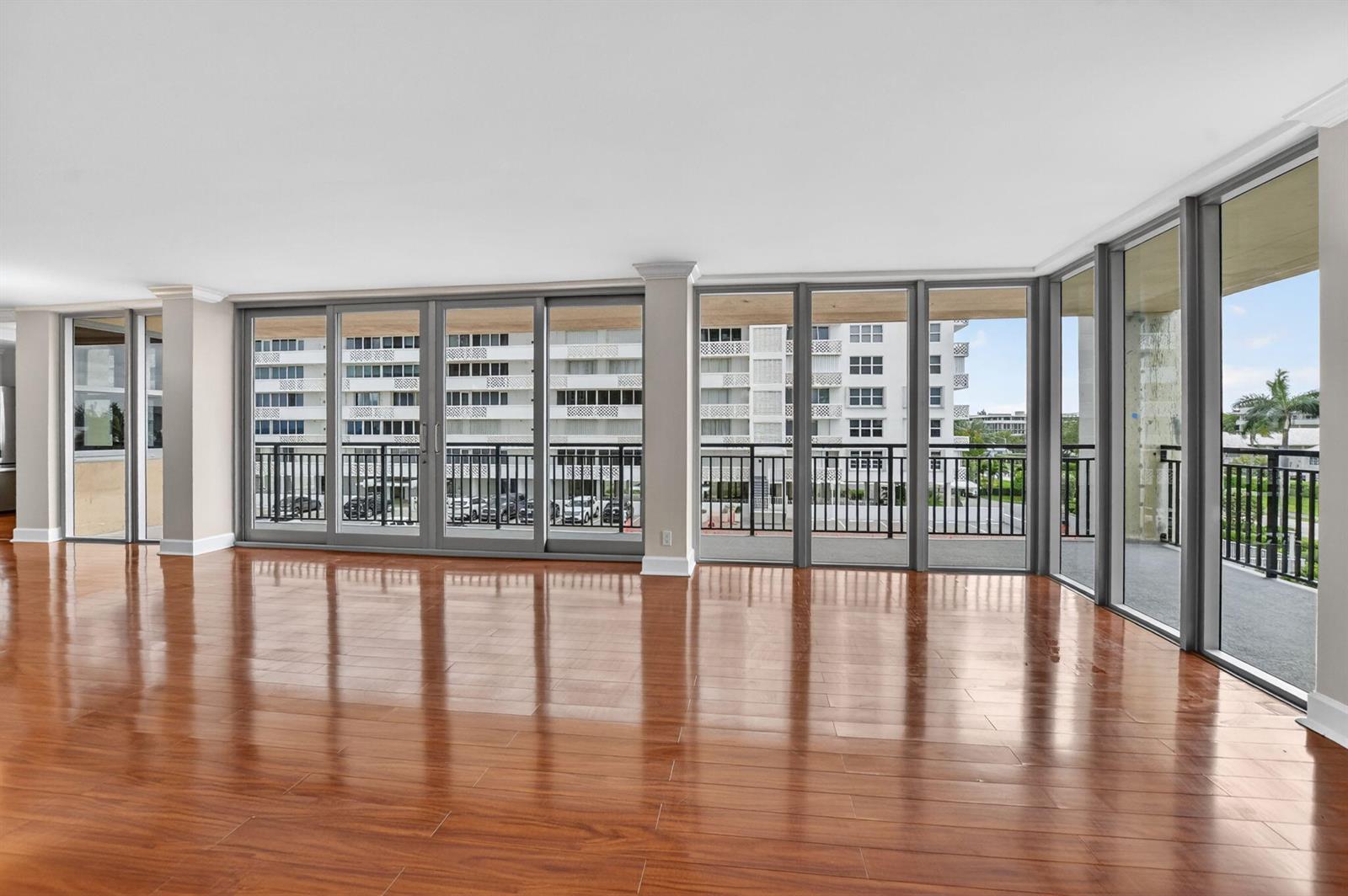 An empty room with polished wood floors and large sliding glass doors leading to a balcony — 1180 S Ocean Boulevard # 3f, Boca Raton FL 33432, BOCA RATON, FL