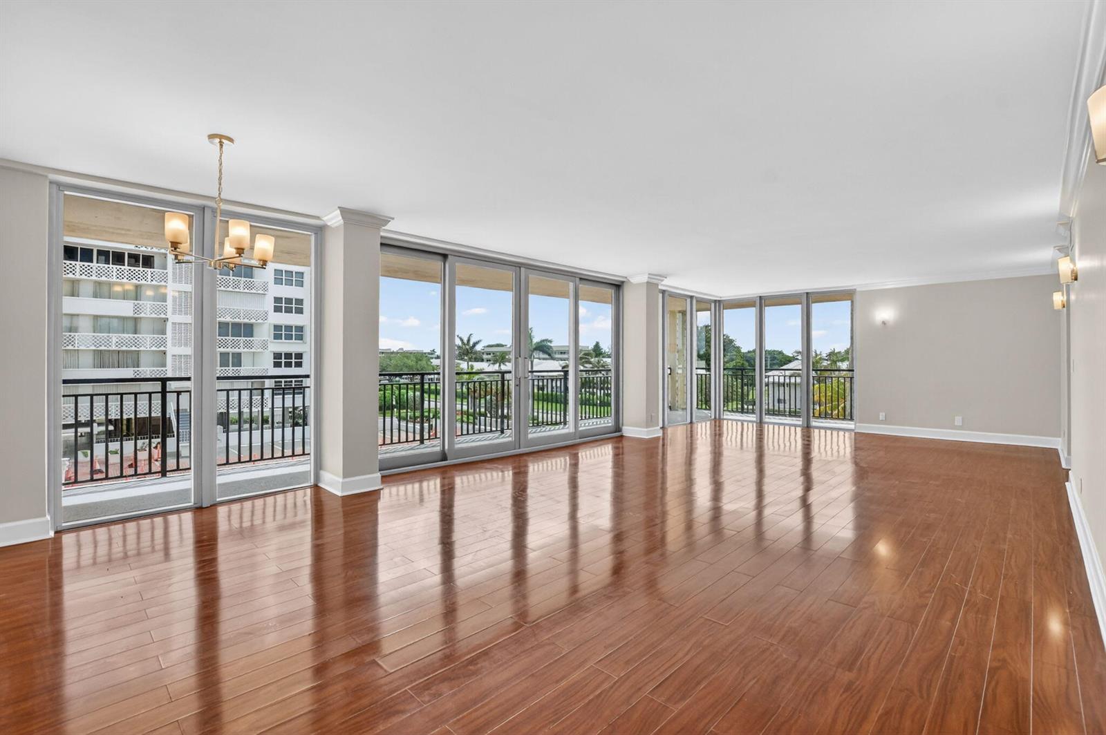 An empty room with hardwood floors, large glass sliding doors, and a balcony view — 1180 S Ocean Boulevard # 3f, Boca Raton FL 33432, BOCA RATON, FL