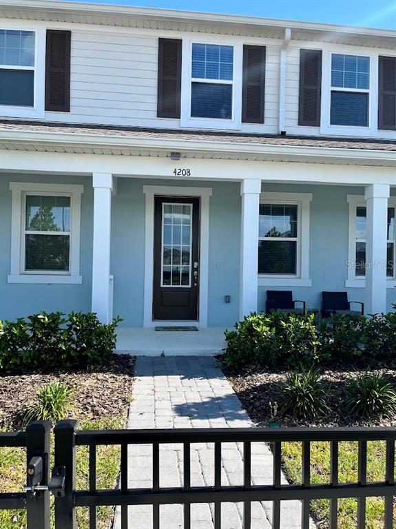 The exterior of a two-story house features light blue siding, white columns, and a front porch — 4208 SADLER ROAD, APOPKA, FL