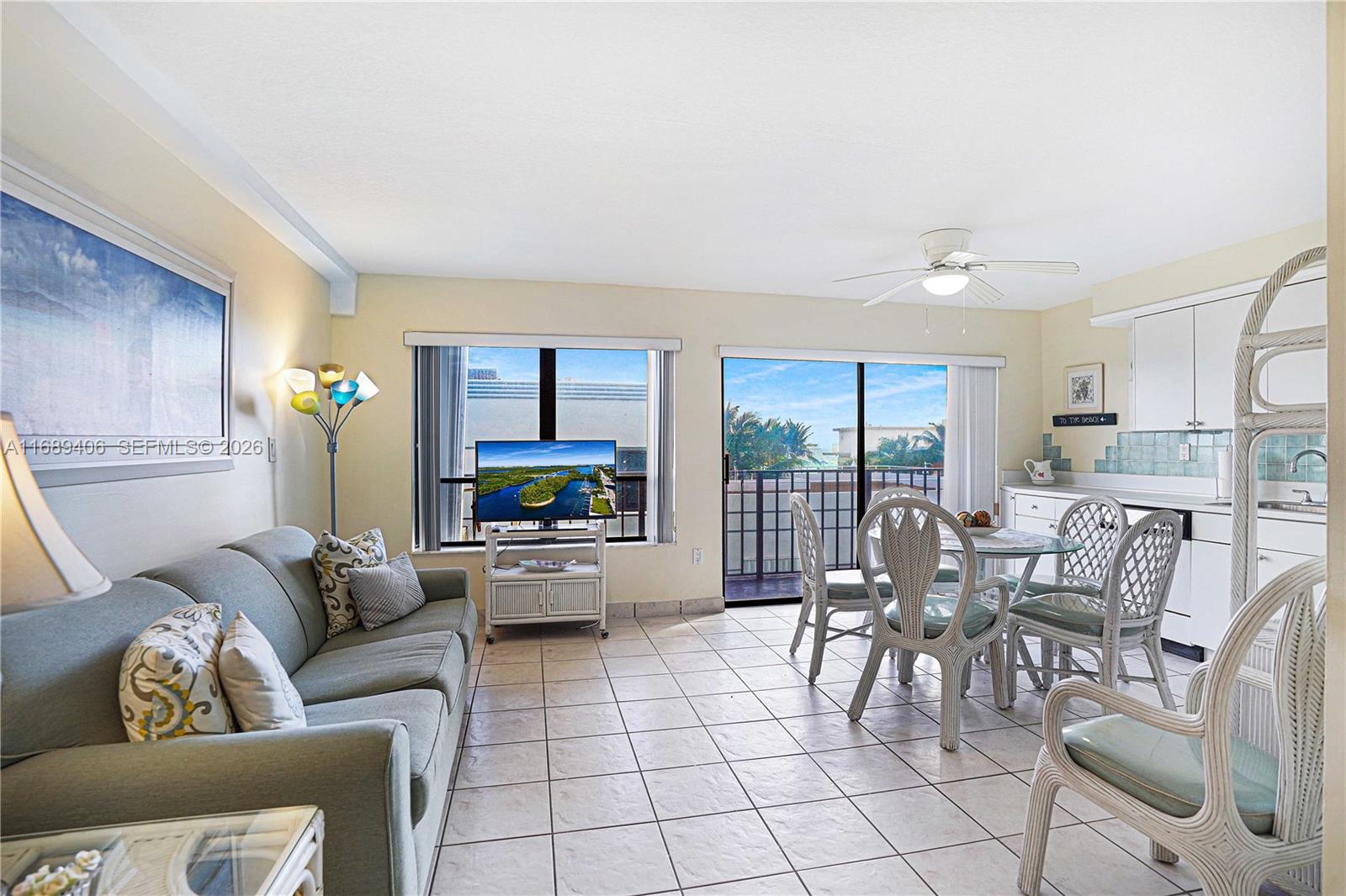 This living and dining area features tile floors, a sofa, and a glass-topped table — 3215 N Ocean Dr # 301, Hollywood FL 33019, HOLLYWOOD, FL