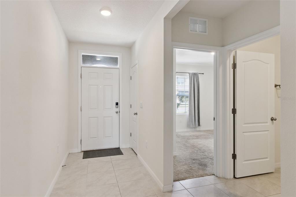 An entryway with tile flooring leads to a carpeted room through an open doorway — 4373 DELEON STREET, HAINES CITY, FL
