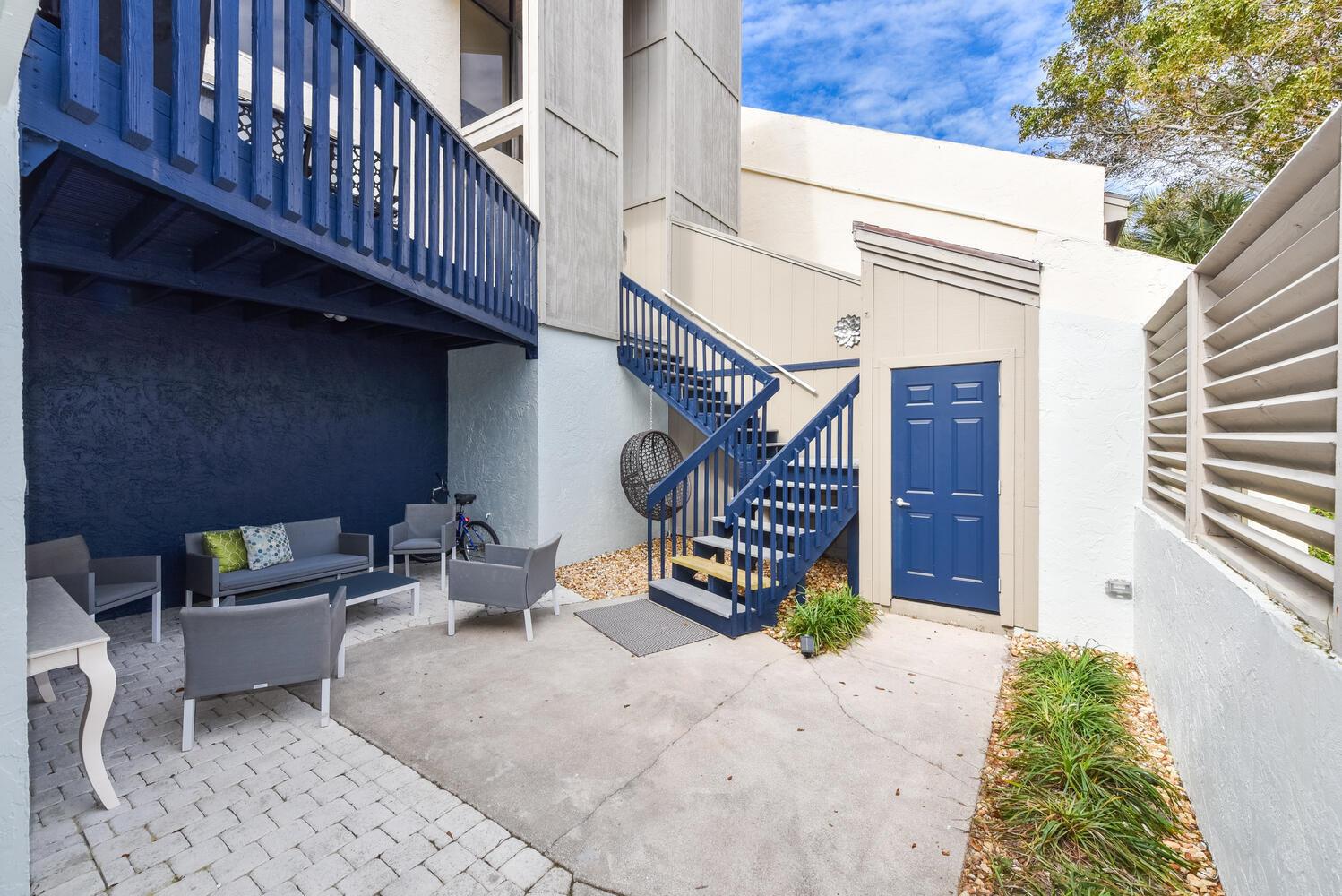 A patio area features outdoor seating, a blue staircase, and a blue storage door — 1605 S Us Highway 1, Jupiter FL 33477, JUPITER, FL