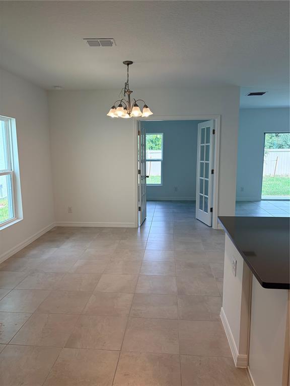A dining area with tile flooring, a chandelier, and French doors leading to another room — 1349 SAWGRASS HAMMOCK LANE, DAVENPORT, FL
