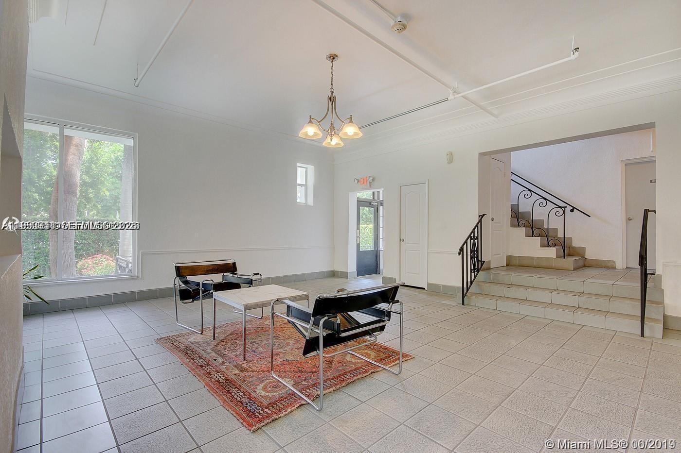 A tiled lobby features two black leather chairs, a small table, and a staircase — 820 Euclid Ave # 106, Miami Beach FL 33139, MIAMI BEACH, FL