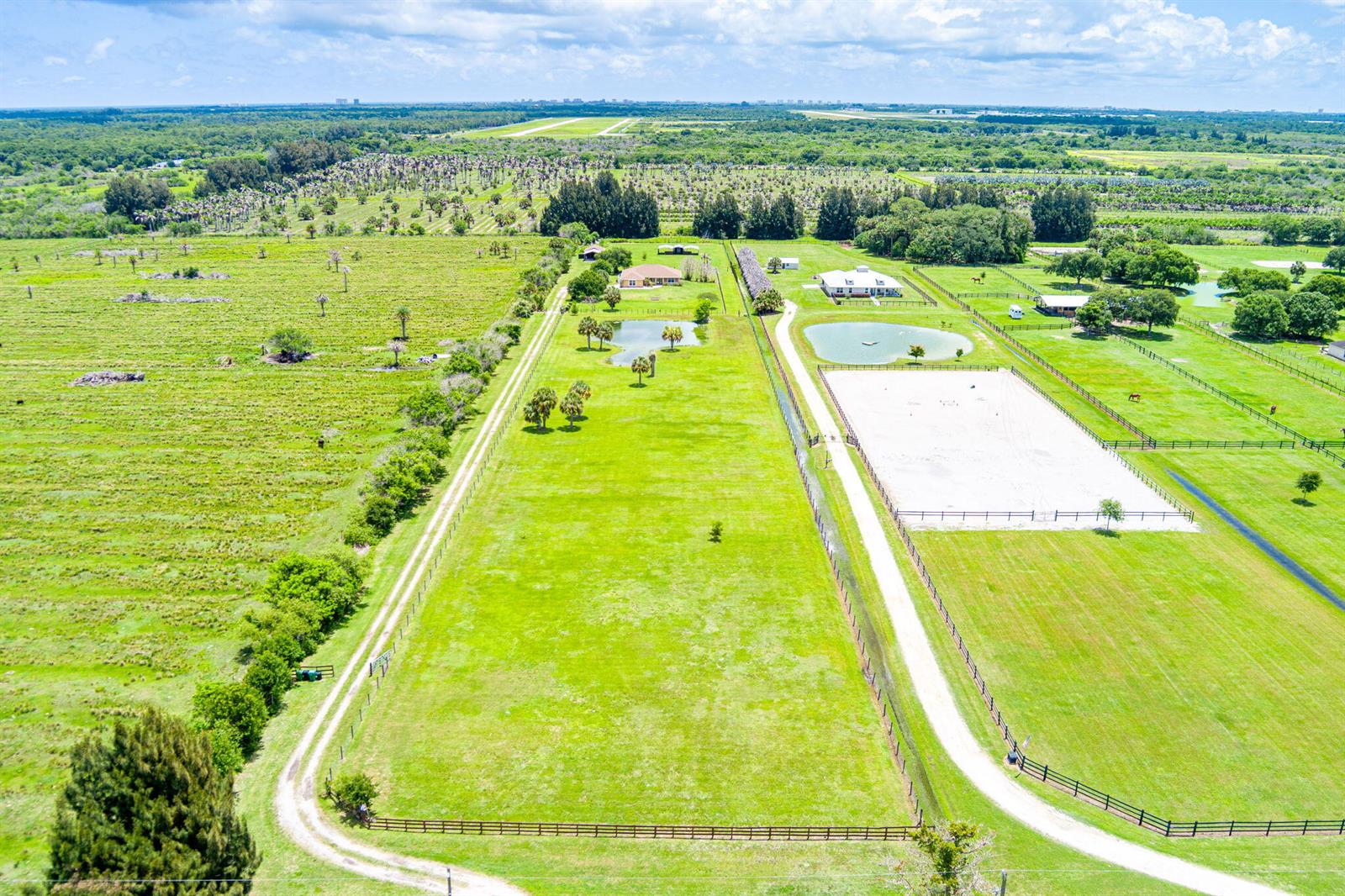 An aerial view shows a rural property with a house, pond, and fenced riding arena — 3768 Seminole Road, Fort Pierce FL 34951, FORT PIERCE, FL