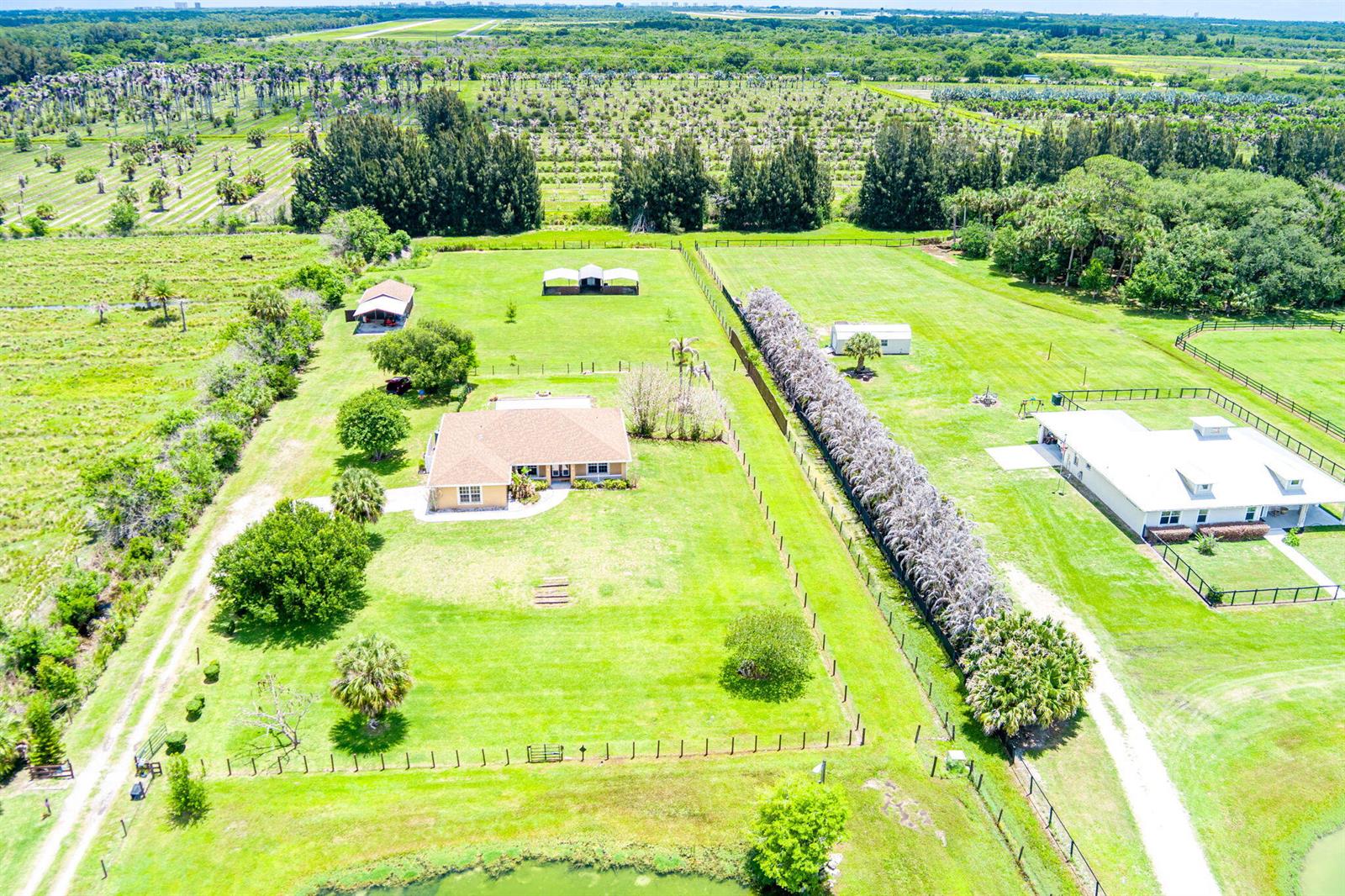 An aerial view shows a residential property with a house, outbuildings, and fenced pastures — 3768 Seminole Road, Fort Pierce FL 34951, FORT PIERCE, FL