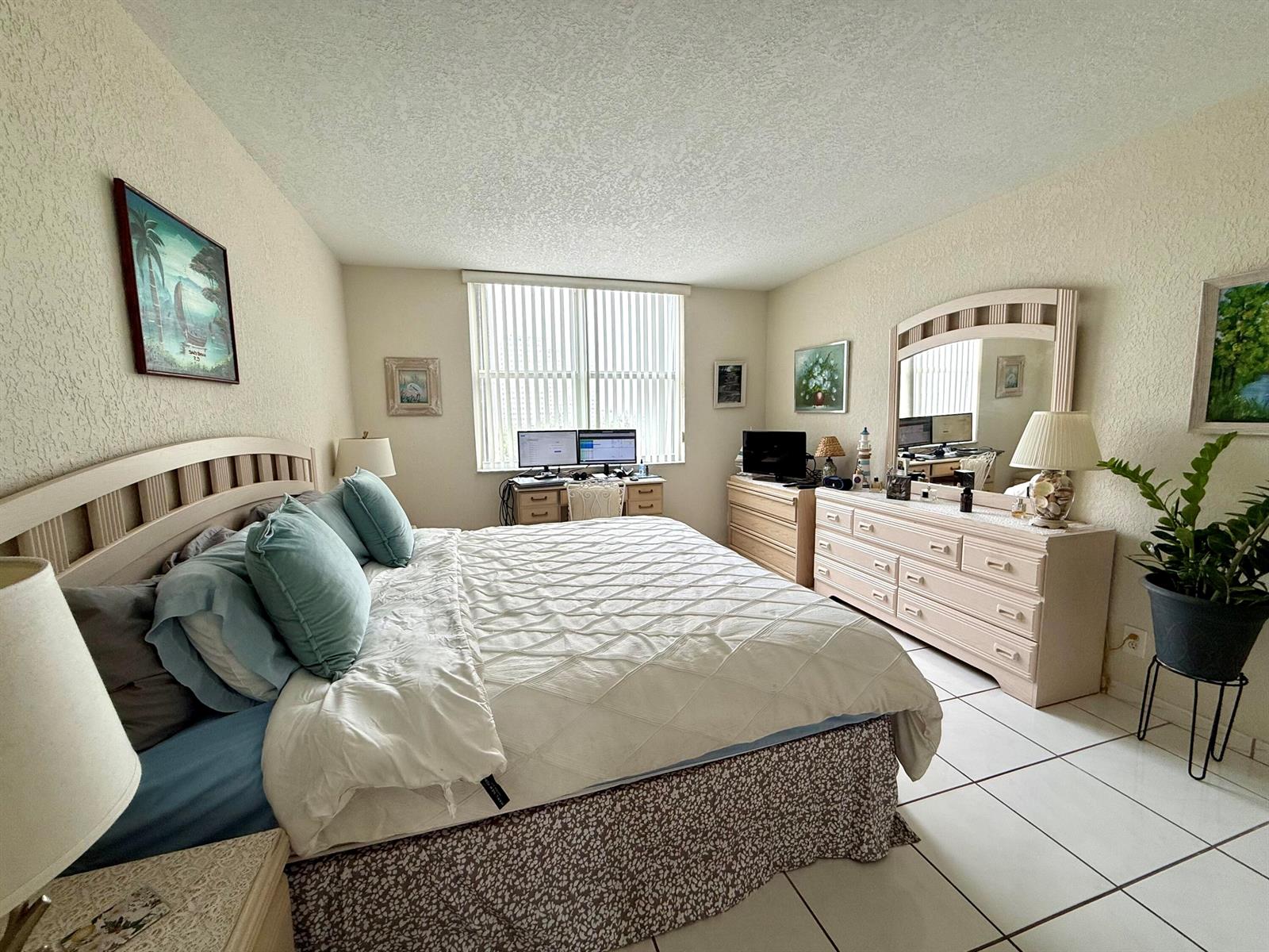 A living room with tile floors, a sofa, a wooden entertainment center, and a balcony — 101 BRINY Avenue # 409, Pompano Beach FL 33062, POMPANO BEACH, FL