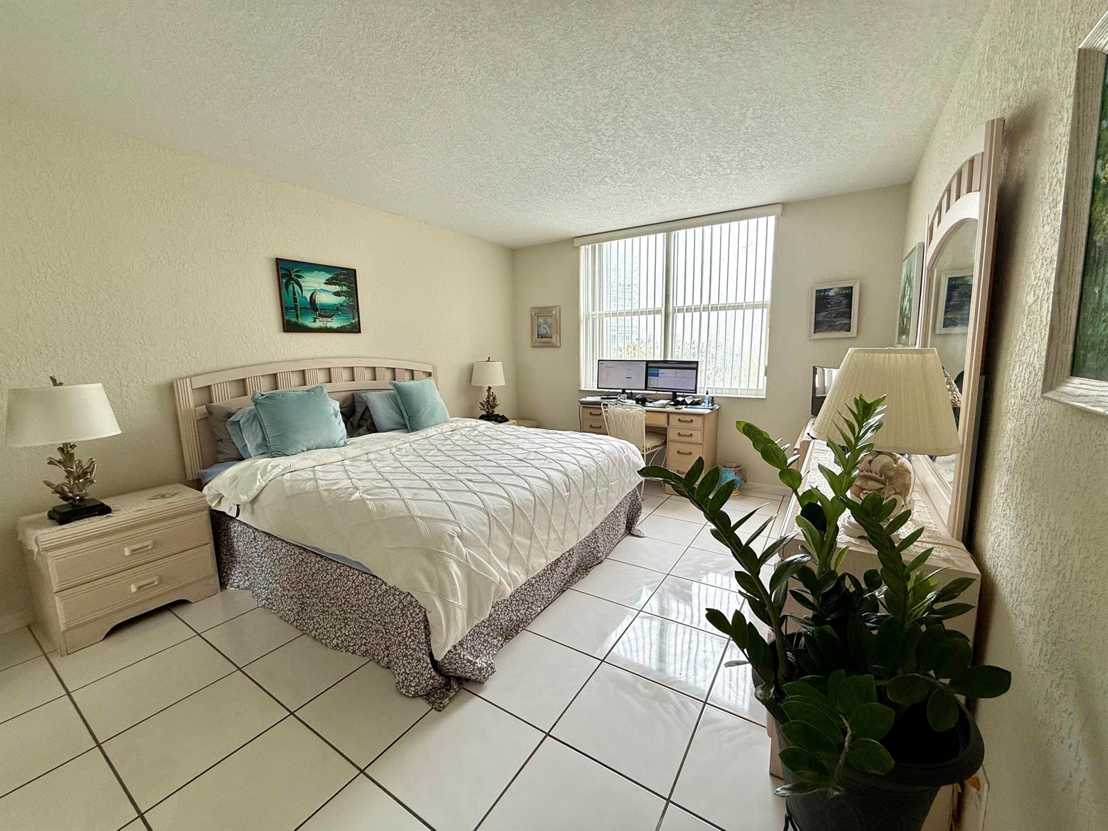 A living room features tile floors, a glass coffee table, and a large wooden entertainment center — 101 BRINY Avenue # 409, Pompano Beach FL 33062, POMPANO BEACH, FL