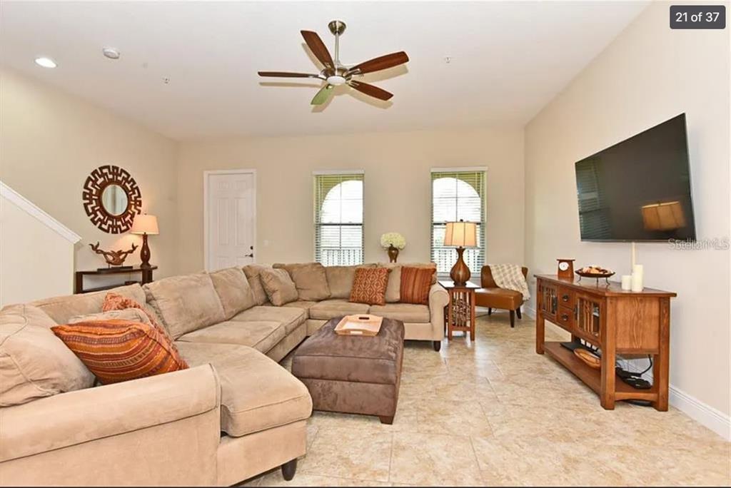 A living room features a large sectional sofa, a television, and tile flooring — 3012 PORTA ROMANO WAY, LAKE MARY, FL